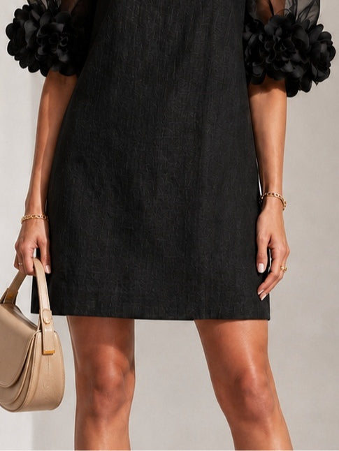 Mini-robe noire en organza avec manches bouffantes et poignets floraux